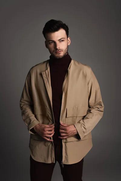 Stylish man in autumn outfit posing isolated on grey