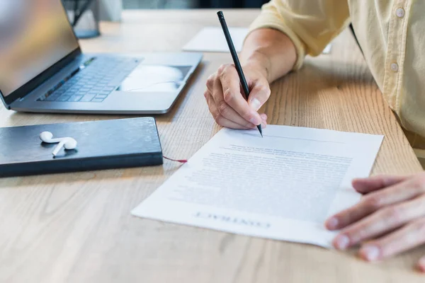 Cropped View Businessman Writing Blurred Contract Notebook Earphones Table — 스톡 사진