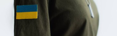 Cropped view of chevron with ukrainian flag on soldier uniform isolated on grey, banner 
