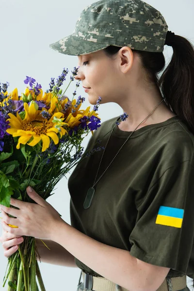 Side View Servicewoman Ukrainian Flag Chevron Smelling Flowers Isolated Grey — стокове фото