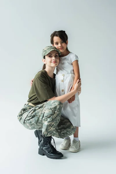 Young Parent Military Uniform Hugging Daughter Grey Background — стоковое фото