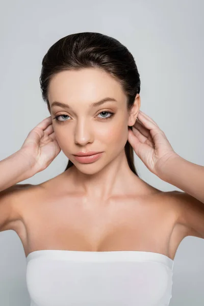 Portrait Young Woman Bare Shoulders Makeup Adjusting Hair Isolated Grey — Fotografia de Stock
