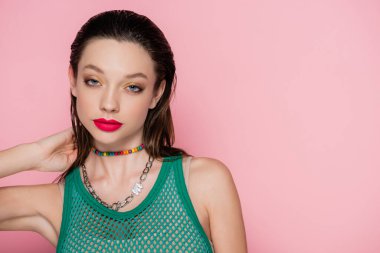 young model with bright makeup looking at camera isolated on pink 