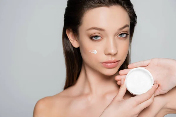 Young Woman Cosmetic Cream Cheeks Holding Container Isolated Grey — стоковое фото
