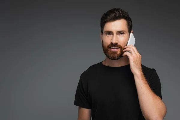 Cheerful Bearded Man Black Shirt Talking Smartphone Isolated Grey — Stock Photo, Image