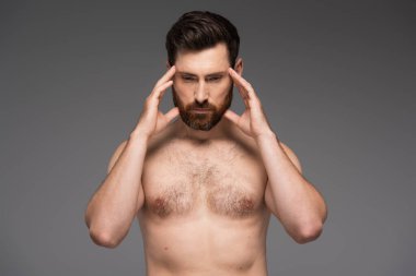 shirtless and thoughtful man with beard touching temples isolated on grey