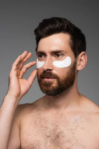 Bearded Man Applying Moisturizing Eye Patches Isolated Grey — Stock Fotó