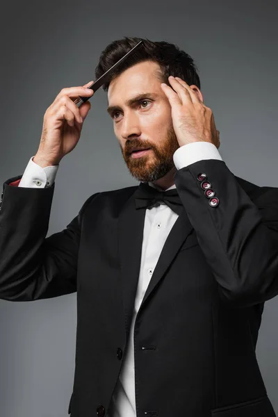 Bearded Man Elegant Tuxedo Brushing Hair Comb Isolated Grey — Fotografie, imagine de stoc