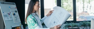 Side view of nonbinary person holding blueprint in creative agency, banner 