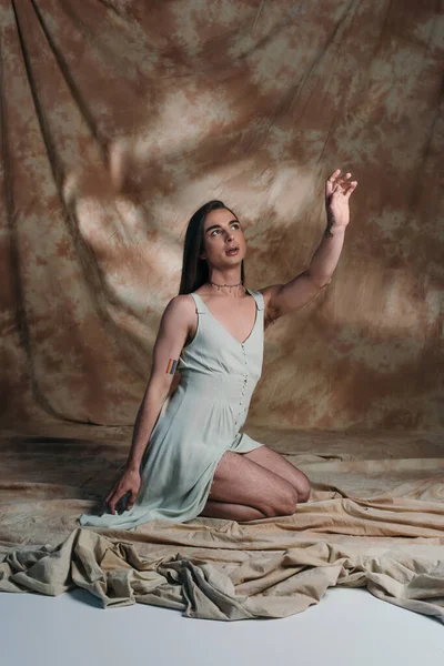 Nonbinary Person Sundress Sitting Gesturing Abstract Brown Background — Foto Stock