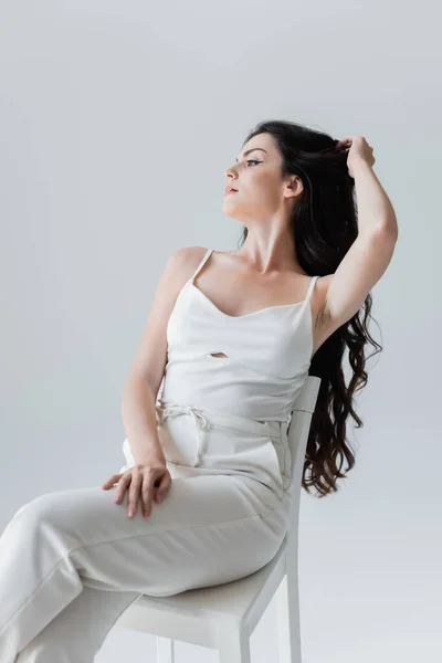 Young Model White Clothes Touching Long Hair While Sitting Chair — Foto de Stock