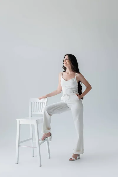 Smiling Woman White Clothes Posing Chair Grey Background — Fotografia de Stock