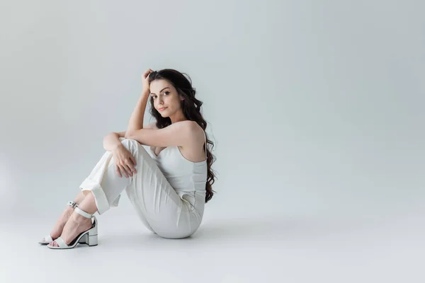 Young Woman Heels White Clothes Looking Camera Grey Background — Stok fotoğraf