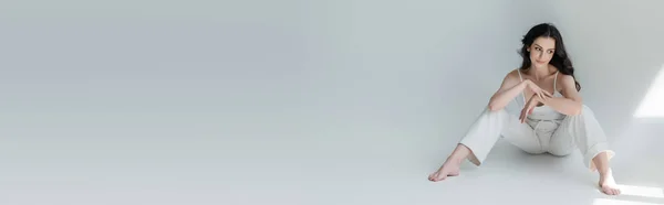 Молода Модель Білому Одязі Дивиться Сонячне Світло Сірому Фоні Банер — стокове фото