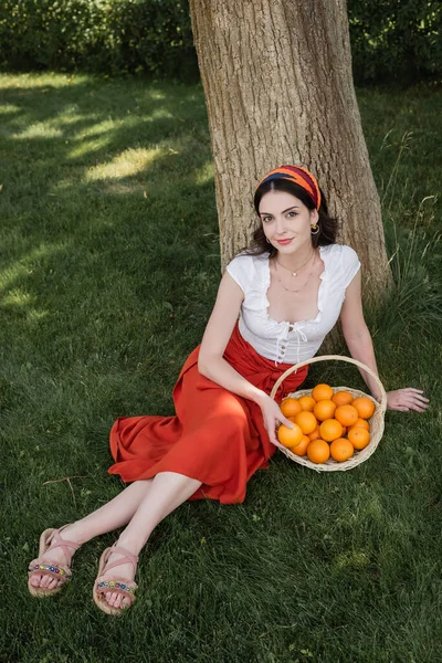 High Angle View Trendy Woman Sitting Oranges Basket Tree Park — Stok fotoğraf