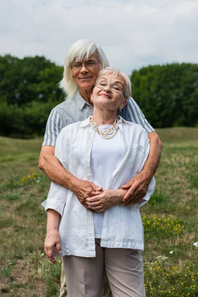 Happy Senior Husband Hugging Wife Grey Hair Standing Park — Stock Fotó