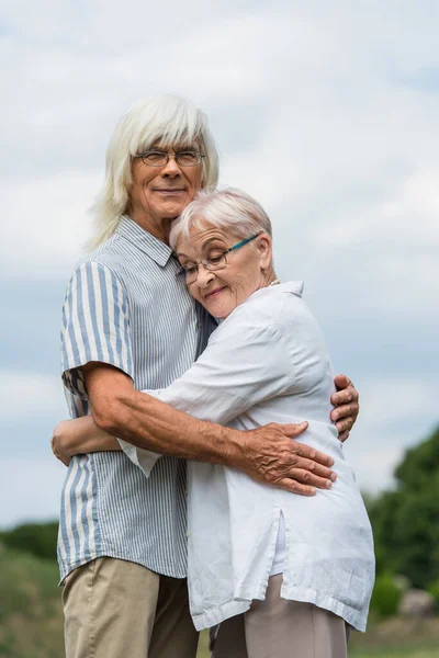 Happy Senior Husband Wife Grey Hair Embracing Cloudy Sky — Stock Fotó
