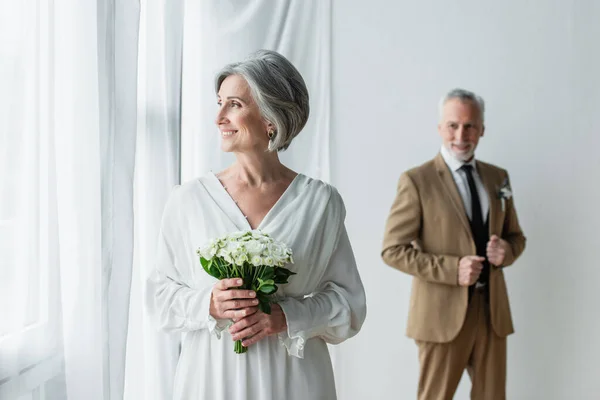 Cheerful Mature Bride White Dress Holding Wedding Bouquet Blurred Groom — 스톡 사진