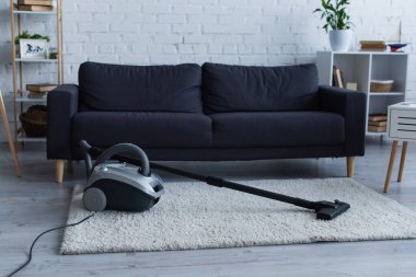 Vacuum cleaner on carpet in living room 