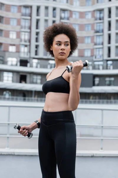 Brunette African American Sportswoman Working Out Dumbbells Looking Away — Fotografia de Stock