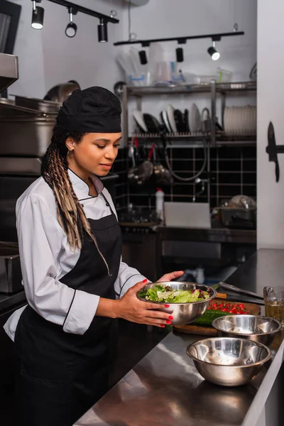 Young African American Chef Holding Bowl Salad Professional Kitchen — стоковое фото