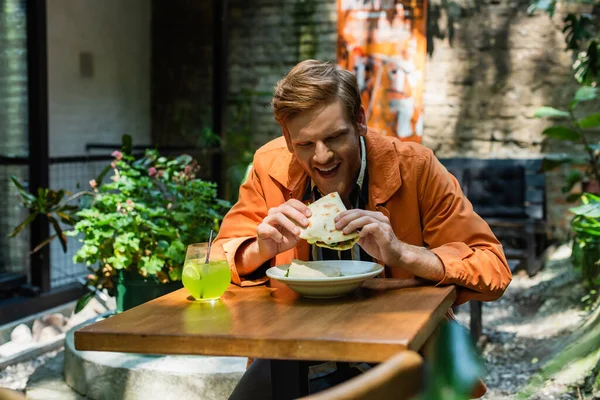 Cheerful Redhead Man Eating Quesadilla Glass Cocktail Outdoor Terrace — Stock Photo, Image