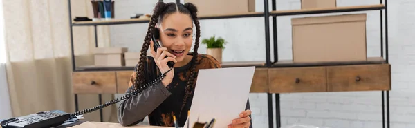 African American Designer Talking Telephone Holding Paper Workshop Banner — Stock Photo, Image