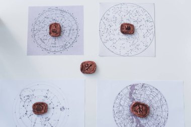 top view of clay runes and constellation charts on white surface clipart
