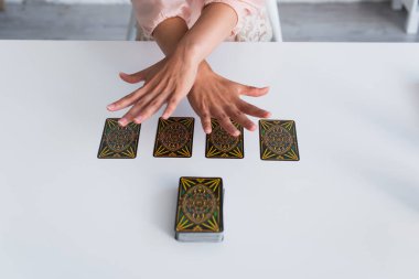 KYIV, UKRAINE - JUNE 29, 2022: partial view of soothsayer predicting on tarot cards during spiritual session