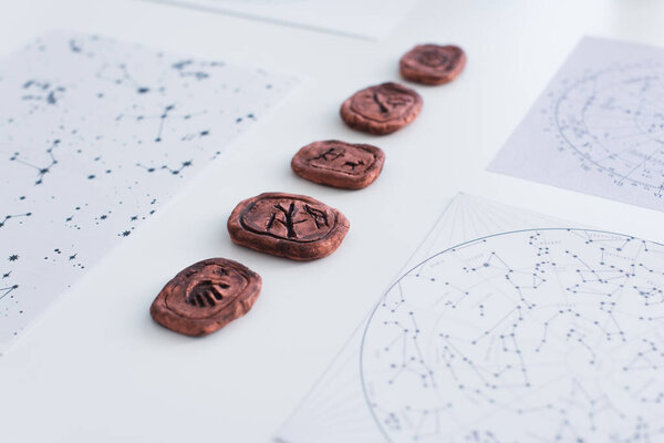 clay runes near star charts on white surface