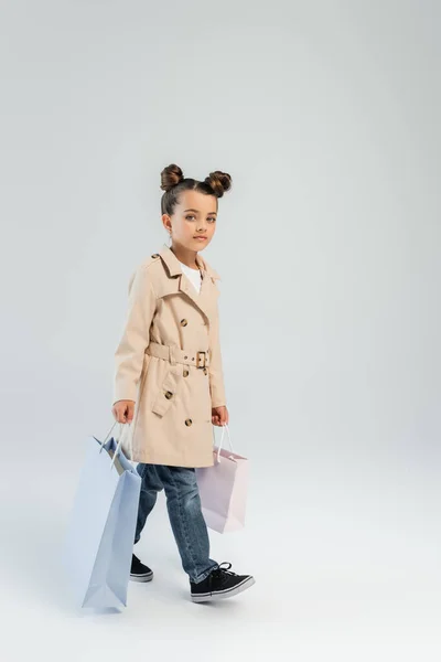 Full Length Stylish Kid Trench Coat Jeans Holding Shopping Bags — Stockfoto