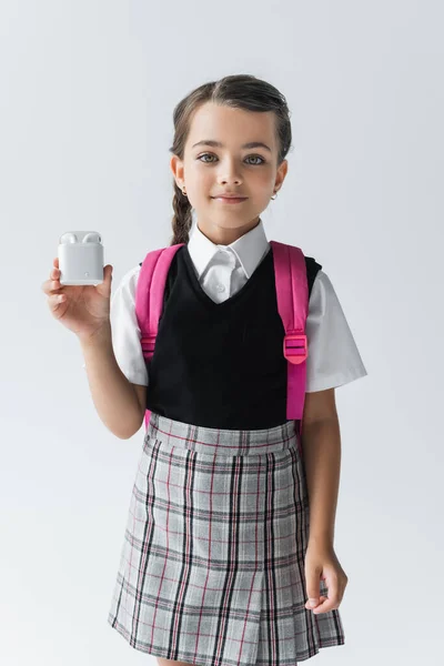 Cheerful Schoolgirl Uniform Standing Backpack Holding Earphone Case Isolated Grey — 스톡 사진