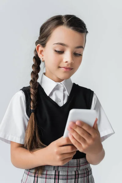 Cute Girl School Uniform Using Smartphone Isolated Grey — стоковое фото