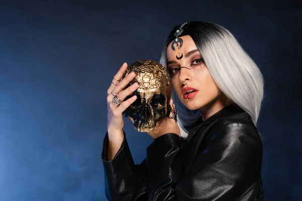 Mulher Maquiagem Bruxa Segurando Crânio Dourado Fundo Escuro Com Nevoeiro — Fotografia de Stock