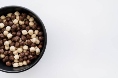 Mısır gevreği toplarının üst görüntüsü çikolata ve vanilya aromalı beyaz kasede izole. 