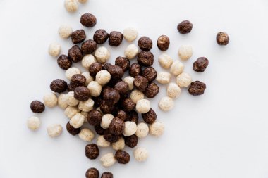 Beyaz üzerine izole edilmiş çikolata ve vanilya aromalı mısır gevreği toplarının üst görüntüsü 