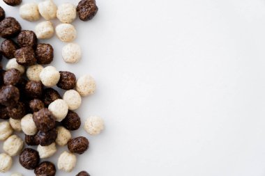 Beyaz üzerine izole edilmiş vanilya ve çikolata aromalı mısır gevreği toplarının üst görüntüsü 