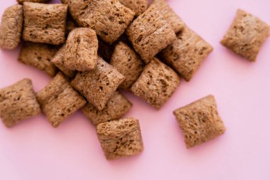 top view of breakfast cereal puffs isolated on pink  clipart