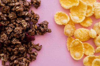 Çıtır mısır gevreği ve pembeye izole edilmiş gevrek granola manzarası. 