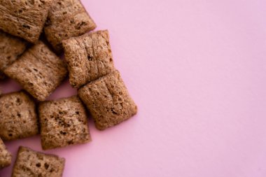 top view of chocolate cereal puffs isolated on pink with copy space clipart