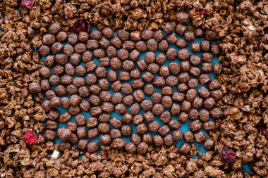 Çıtır çikolatalı granola yakınlarındaki lezzetli mısır gevreği toplarının üst görüntüsü. 