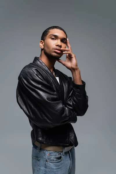 Ung Afrikansk Amerikansk Man Läder Jacka Vidröra Ansiktet Medan Poserar — Stockfoto