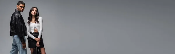 Брюнетка Жінка Шкіряній Спідниці Тримає Чорний Піджак Біля Стильного Афроамериканського — стокове фото