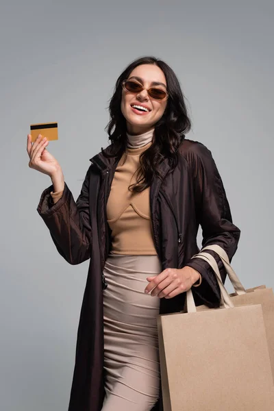 Sorrindo Jovem Mulher Óculos Sol Elegantes Segurando Sacos Compras Cartão — Fotografia de Stock