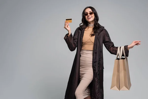 Sorrindo Jovem Mulher Óculos Sol Elegantes Segurando Sacos Compras Cartão — Fotografia de Stock