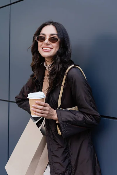 Mujer Joven Sonriente Traje Elegante Gafas Sol Sosteniendo Taza Papel —  Fotos de Stock