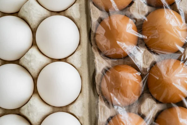 セロハンとトレイの白と茶色の鶏の卵のトップビュー — ストック写真