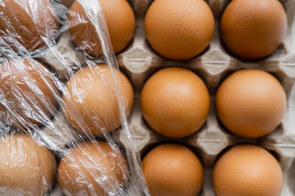 容器内の茶色の鶏の卵にセロハンのトップビュー — ストック写真
