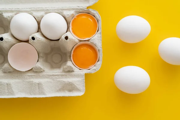 Bovenaanzicht Van Natuurlijke Dooiers Buurt Van Eieren Container Gele Achtergrond — Stockfoto
