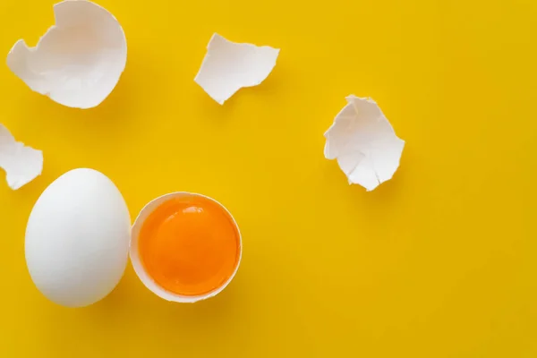 Κάτοψη Του Κρόκου Κοντά Σπασμένα Κελύφη Και Αυγό Κίτρινο Φόντο — Φωτογραφία Αρχείου